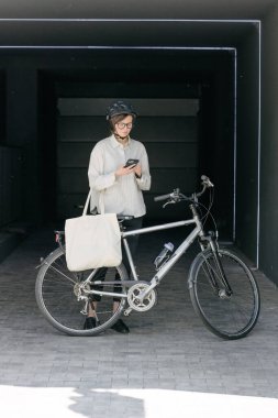 Eko çanta ya da pamuklu çanta taşıyan bir kadın şehirde bisiklet sürerken