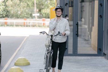 Eko çanta ya da pamuklu çanta taşıyan bir kadın şehirde bisiklet sürerken