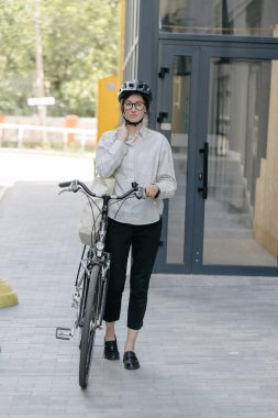 Eko çanta ya da pamuklu çanta taşıyan bir kadın şehirde bisiklet sürerken