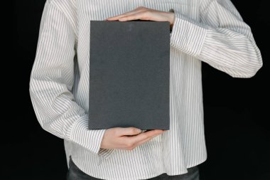 Model için elinde siyah boş bir kitap kapağı tutan kadın.