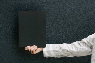 Model için elinde siyah boş bir kitap kapağı tutan kadın.