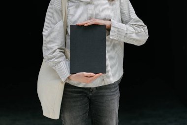 Model için elinde siyah boş bir kitap kapağı tutan kadın.