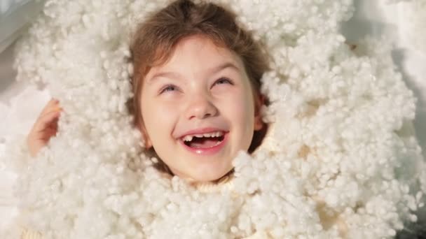 Neşeli Küçük Kız Neşeyle Beyaz Hava Yastığı Dolgusu Yığınına Uzanıp — Stok video