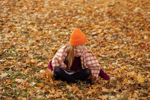 귀엽고 모자를 스카프와 스웨터를 나이든 여학생 나뭇잎을 — 스톡 사진
