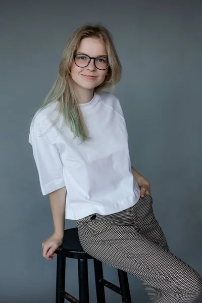 Молода Усміхнена Жінка Окулярах Офісному Вбранні Сидить Стільці Сірому Фоні — стокове фото