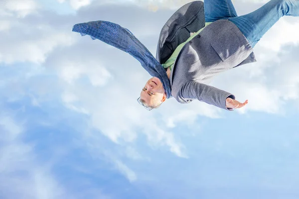 Перевернутое Изображение Человека Куртке Шарфе Прыгающего Высоко Смотрящего Камеру Облачном — стоковое фото