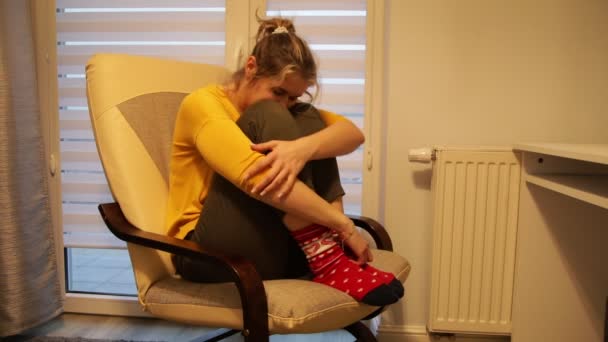 带着昏暗灯光的可悲女人坐在电脑前的椅子上 依偎在膝上 低着头 中央供暖问题 生活困难 — 图库视频影像