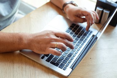 Açık internet kafede dizüstü bilgisayarda çalışan tanınmayan, biçilmiş adam elleri. İş finans sektörü ve bilişim sektörü, pazarlama. Çevrimiçi webinar, e-öğrenme ve kurslar. Üst, yüksek açı görünümü