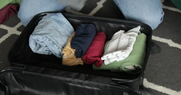 Woman Put Wrapped Leisure Clothes Black Suitcase Lying Floor Home — Wideo stockowe