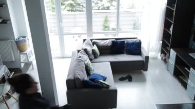 Timelapse of middle-aged woman spending time at home, doing housework, looking at window, lying on sofa, playing with dog, stroking pet Cavalier King Charles spaniel, washing floor. Top view. Routine.