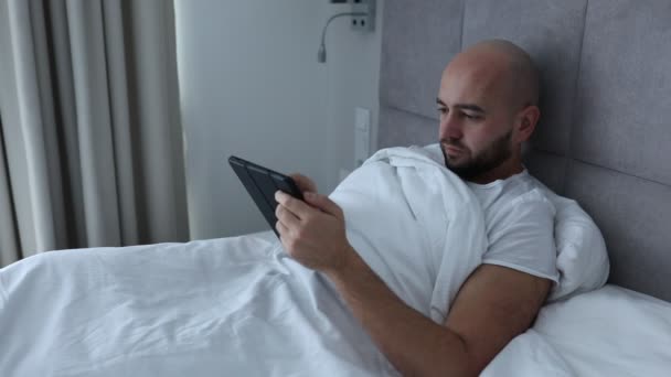 Mature Bearded Man Using Digital Tablet Lying Wrapped White Linen — Stockvideo