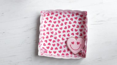Womens hands put in box smiling gingerbread in shape of smiling hearts wonderful gift for Valentines Day. High quality FullHD footage