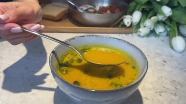 Female hands with light manicure, unrecognizable woman, holding spoon, ceramic plate. Pumpkin cream soup, dinner in restaurant, vegetarian meal 