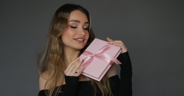 Νεαρή Γοητευτική Νεαρή Γυναίκα Χαμόγελο Δείχνει Ροζ Κουτί Δώρου Ασορτί — Αρχείο Βίντεο