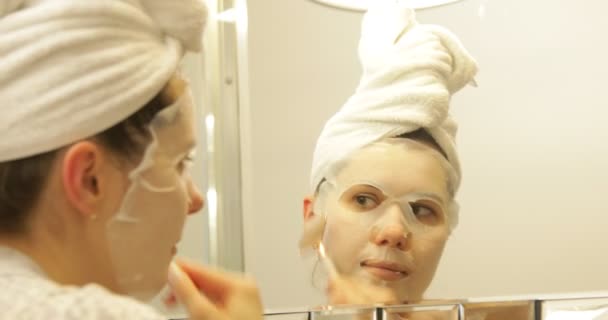 Odaklanmış Genç Bir Kadın Banyoda Havluya Sarılmış Saçlarıyla Aynadaki Yansımaya — Stok video
