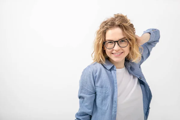 stock image Attractive young red-haired woman with glasses, with stylish hairstyle smiles at camera, putting her hand behind her head. Health and beauty. Positive emotions. Life insurance. Protecting your life.