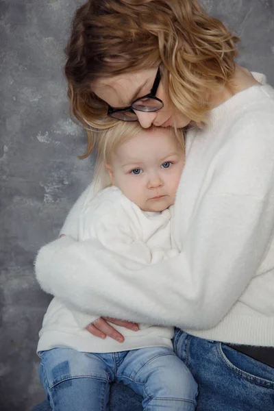 곱슬머리에 안경을 청바지를 스웨터를 어머니는 기대어 자기와 똑같은 부드럽게 껴안는다 — 스톡 사진