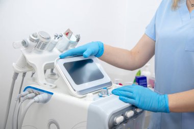 El parçaları ve kablolarla Hydra yüz soyma makinesi kurup kullanan profesyonel bir dermatolog. Kaplıca kliniğinde yüz bakımı. Elektroliz anti-yaşlanma teknolojisi, hijyen 