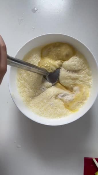 女性の手はボウルに浸漬ミキサーで生の液体生地をホイップ 垂直調理ビデオのトップビュー シャルロットケーキ アップルパイの伝統的なレシピ 自家製デザート シャーロット料理 — ストック動画