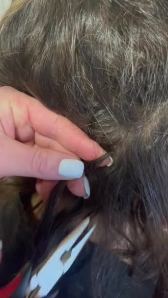 在美容院的特写镜头中剪掉头发 理发师用乳头捏碎人造发囊的手 黑发女人长头发的头 美容美发 — 图库视频影像