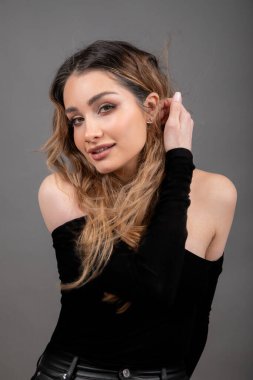 Uzun, gevşek saçlı ve kameraya cilveli gülümseyen çekici genç bir bayan model. Güzel kadın omuzları çizgisi. Deri ve saç bakımı. Profesyonel makyöz. Güzellik salonu. Sağlık ve güzellik. 