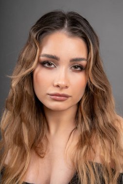 Uzun bakımlı saçları ve profesyonel makyajı olan genç ve güzel bir mankenin portresi. Deri ve saç bakımı. Profesyonel makyöz. Güzellik salonu. Kaş dövmesi var. Güzel kadınlar..