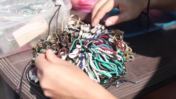 Vídeo Mãos Masculinas Irreconhecíveis Escolhendo Ordenando Concha Mar Pulseiras Pérola — Vídeo de Stock