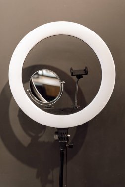 LED lambasının telefon sahibi yakın plan, profesyonel güzellik blogları için ayna gri arkaplandaki vlog kaydı. Makyaj dersi, selfie, teknoloji, fotoğraf, Youtube. Dikey.