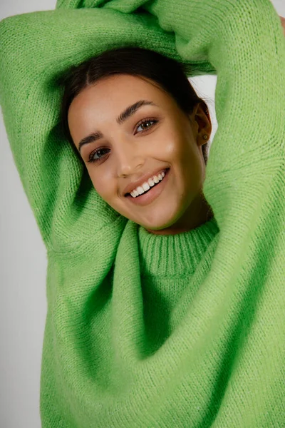 Vacker Kvinna Ljusgrön Enfärgad Pullover Med Upphöjda Armar Beröringshuvud Kvinnlig — Stockfoto