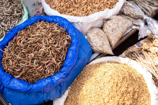 Bunch of cooked various, little insects laid out in huge bags selling in Goa street market as delicacy. Brown, white worms and larvae at Indian trading. Protein snacks and fast food on market.