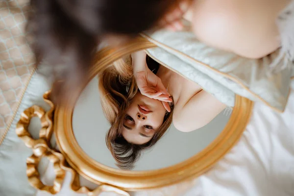Morena Encantadora Deitada Cama Com Lençóis Brancos Olhando Para Espelho — Fotografia de Stock