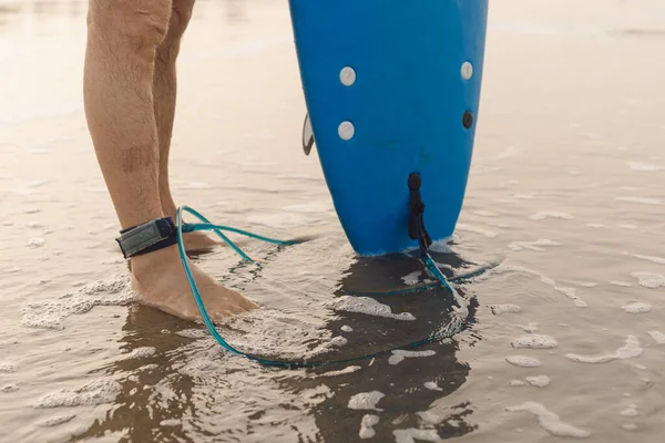 발목에 해변에 서있는 수없는 남자의 다리와 마자린 보드를 해변에서 서핑을 — 스톡 사진