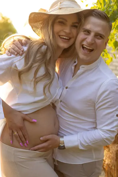Feliz Pareja Casada Embarazada Ríe Alegremente Atardecer Naturaleza Abrazando Tocando — Foto de Stock
