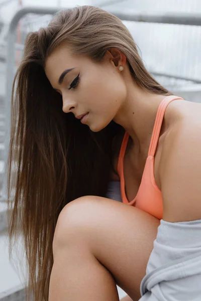 Beauty and health. Perfect young fresh skin. Close-up of beauty girl with luxurious long hair makeup in sports top posing outside on summer day. Hair and body care. Fitness and health. H