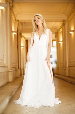 Güzel sarışın gelinin uzun bir portresi. İçinde lüks bir gelinlik var. Düğün havası. Romantizm. Güzellik modası. Düğün organizasyonu. Modaya uygun gelinlikler.. 