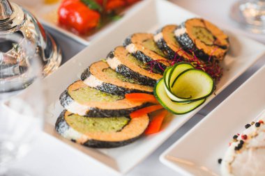 Doldurulmuş balıklı beyaz tabak ve festival masasında yeşilliklerle süslenmiş. Lezzetli atıştırmalıklar. Zevk alıyorum. Şenlik etkinlikleri düzenliyorum. Profesyonel yemek hazırlama. İmza tarifleri. 