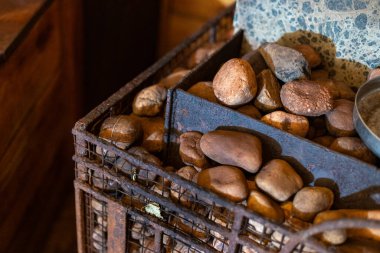 Elevate home decor with distressed metal basket filled with river rocks for rustic charm in indoor space clipart