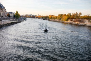 Paris, Fransa 'daki Seine nehrinin üzerinde, turist kanalı tekneleriyle güzel, canlı bir günbatımı. Yüksek kalite fotoğraf