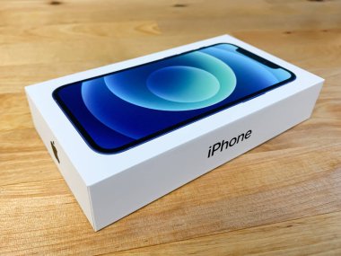Apple iPhone 12 tahta masadaki kutuda, açılı kenar görüş.