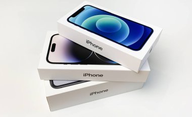 Elma iPhone 'ları beyaz masaya istiflenmiş kutularda. iPhone 14 Pro, 12 ve XR.