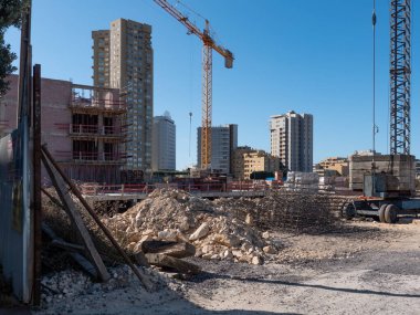 Yeni apartman yapım aşamasında. Temeller atılırken molozlarla dolu bir inşaat alanı. Geniş açı.