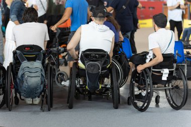 Üç Çocuğun Arkasından Tekerlekli Sandalyelerinde oturan ve diğer insanları izleyen.