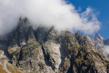 Güneşli bir yaz gününde İtalyan Alplerinin sıradağları, Kayaların ve Bulutlu Mavi Gökyüzünün yakın görüntüsü.