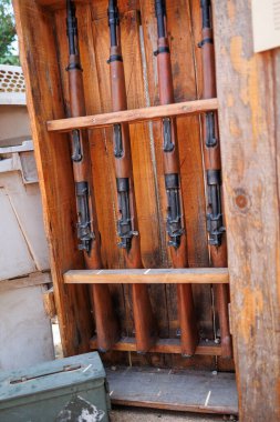 Tahta raflarına yerleştirilmiş dört silah..