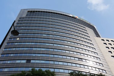 Curved Facade of a Tall Modern Building with Mirrored Windows.