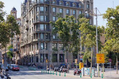 Barcelona 'nın merkezindeki birçok katın karakteristik binası Ağaçlarla çevrili ve İspanya' nın en yakındaki caddesinde insanlar var..