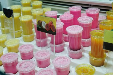 Muz, greyfurt, portakal, kivi aromalı buzlu meyve suyu. Plastik bardakların içinde..