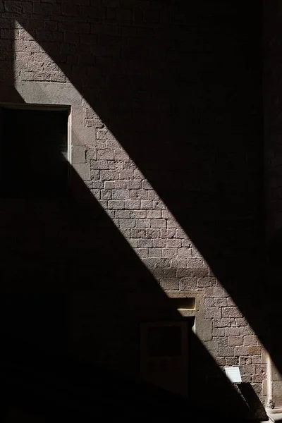 Diagonal Light Beam Passing Through a Stone Wall with Windows, Contrast - Light and Dark.