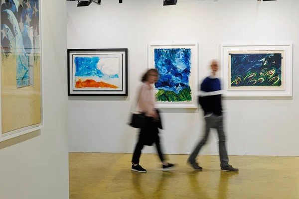 Stock image People Walking and Admiring Paintings in a Modern Art Gallery.