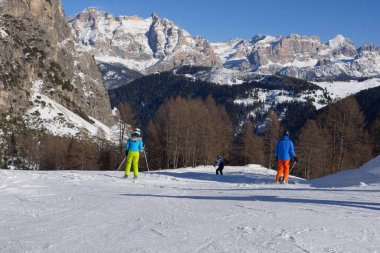 Bolzano, İtalya - Şubat 2023: Güzel Karlı bir yamaçtan inen Alp Kayakçıları ve İtalyan Alpleri Dolomite Dağları 'nın karla kaplı güzel manzarası.